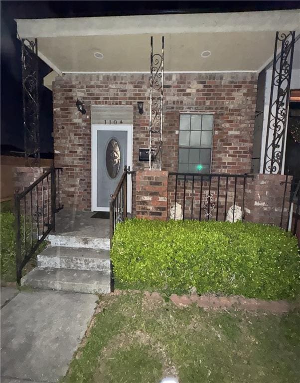 entrance to property featuring brick siding