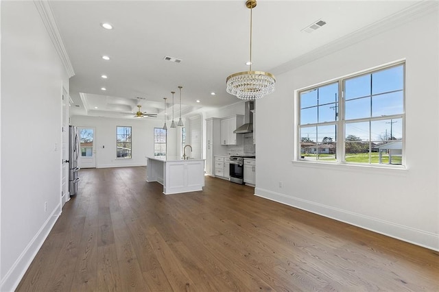 unfurnished living room featuring baseboards, visible vents, dark wood finished floors, crown molding, and a sink