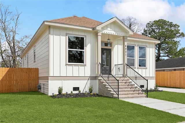 bungalow featuring a shingled roof, crawl space, fence, a front lawn, and board and batten siding