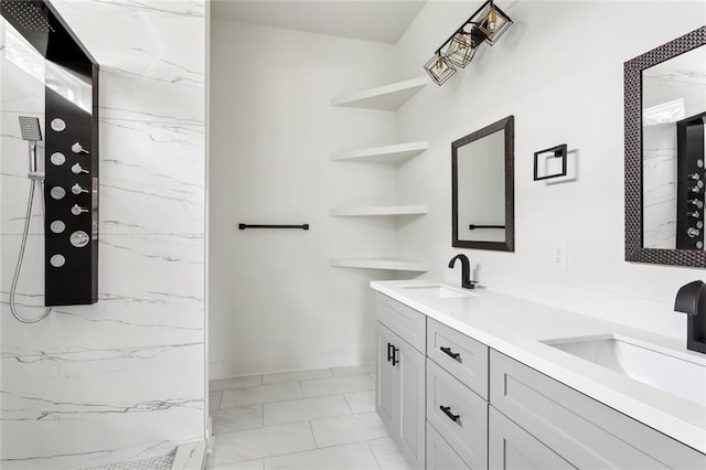 full bath featuring double vanity, marble finish floor, a marble finish shower, and a sink