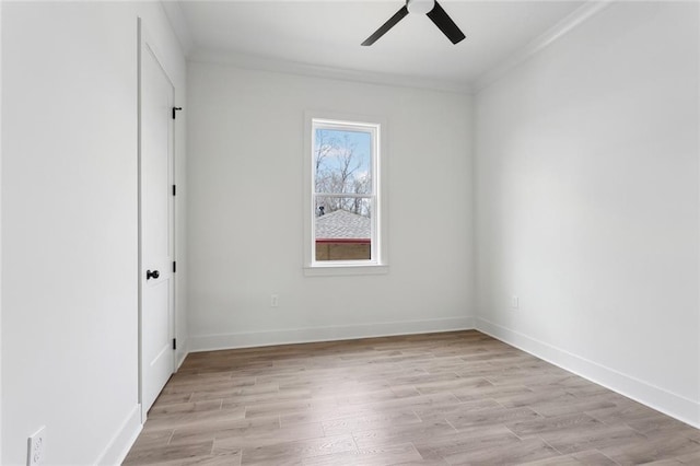 unfurnished room with ornamental molding, light wood-style flooring, and baseboards