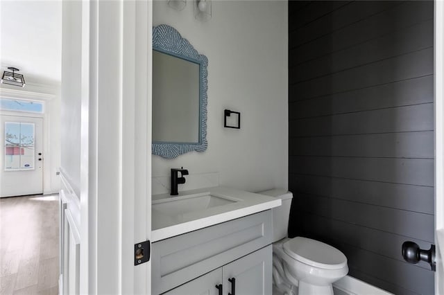 bathroom featuring vanity, toilet, and wood finished floors