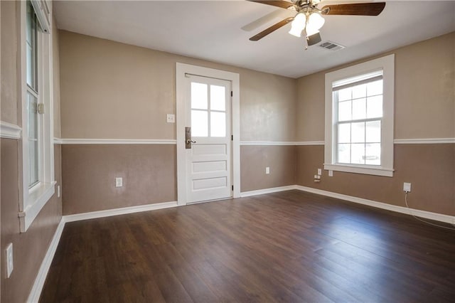 interior space featuring a ceiling fan, wood finished floors, visible vents, and baseboards