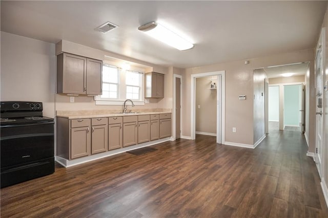 kitchen featuring black range with electric stovetop, a sink, visible vents, gray cabinets, and dark wood-style floors