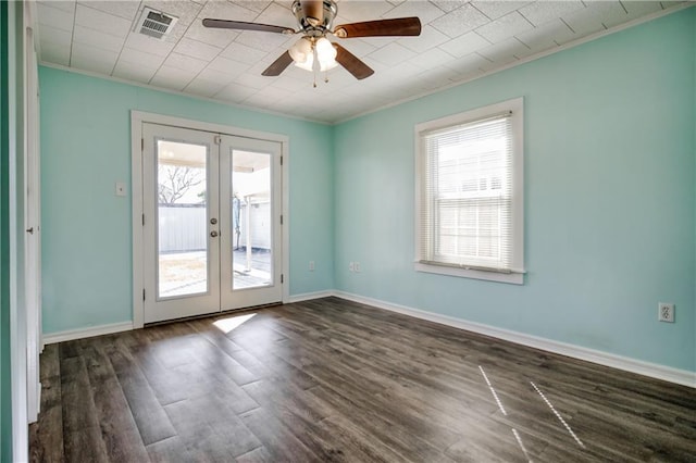 empty room featuring baseboards, visible vents, dark wood-style flooring, crown molding, and french doors