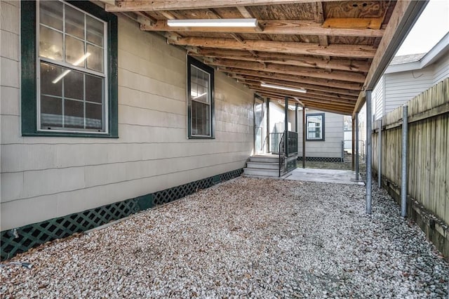 view of patio featuring fence and a carport