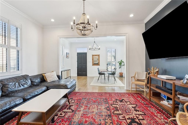 living room featuring recessed lighting, wood finished floors, an inviting chandelier, and ornamental molding