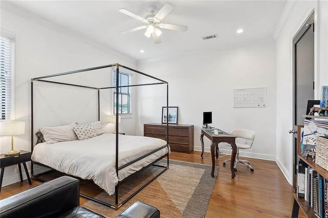 bedroom featuring visible vents, crown molding, baseboards, recessed lighting, and wood finished floors