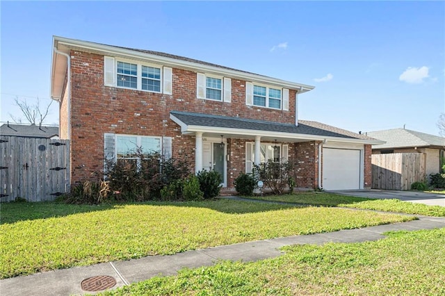 traditional-style home with brick siding, concrete driveway, a front yard, fence, and a garage