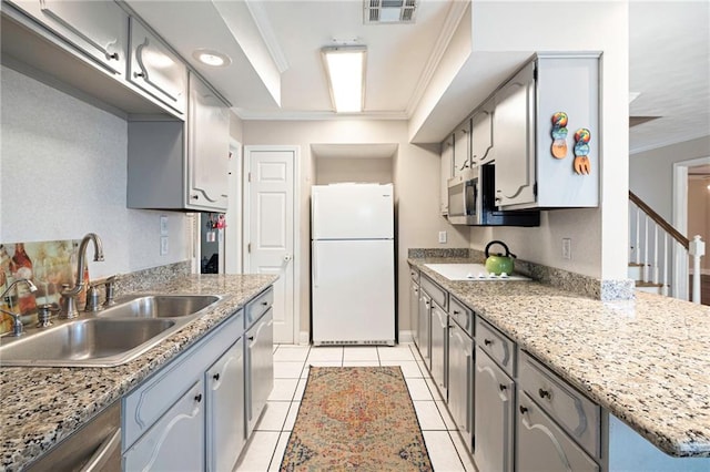 kitchen with light tile patterned floors, stainless steel appliances, a sink, visible vents, and ornamental molding