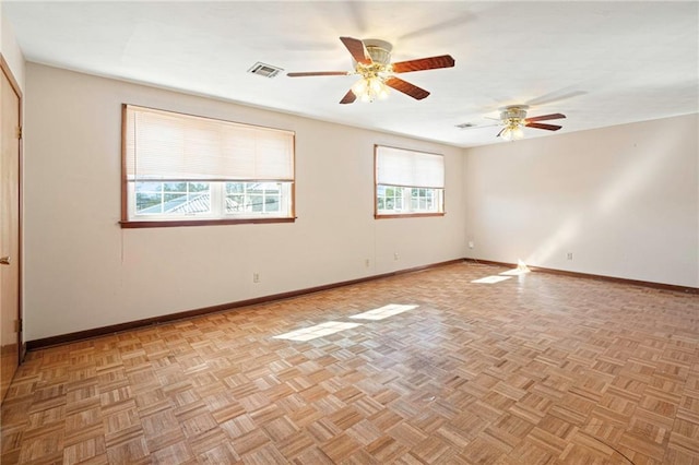 unfurnished room featuring ceiling fan, visible vents, and baseboards