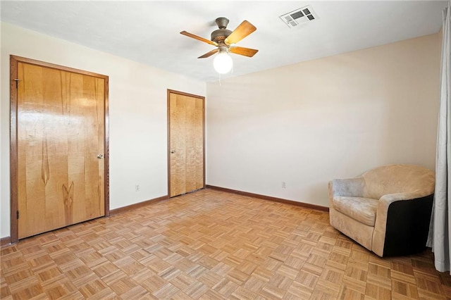 unfurnished room with ceiling fan, visible vents, and baseboards