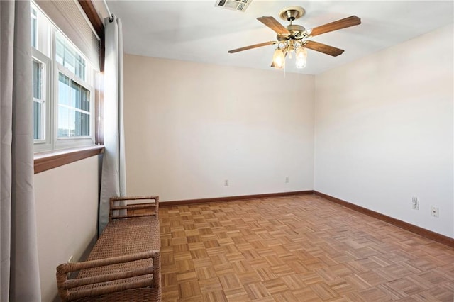 spare room with visible vents, ceiling fan, and baseboards