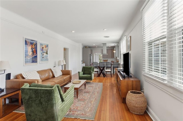 living area featuring recessed lighting, light wood-style flooring, and baseboards