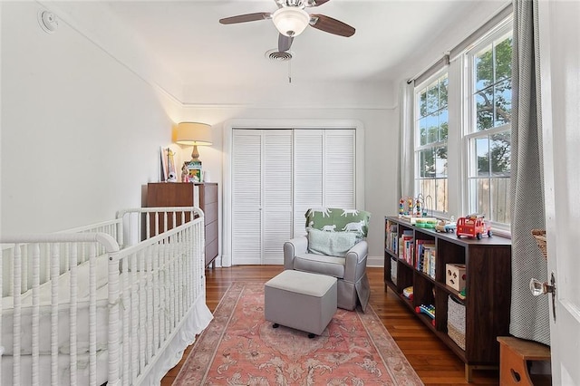 bedroom with a ceiling fan, a closet, visible vents, and wood finished floors