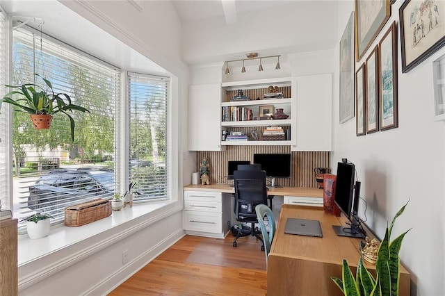 office area featuring light wood-style floors, built in desk, and baseboards