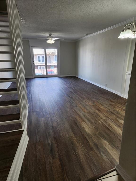 unfurnished living room featuring dark wood-style floors, ornamental molding, a textured ceiling, and ceiling fan with notable chandelier