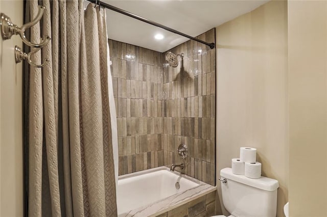 bathroom with tiled shower / bath and toilet