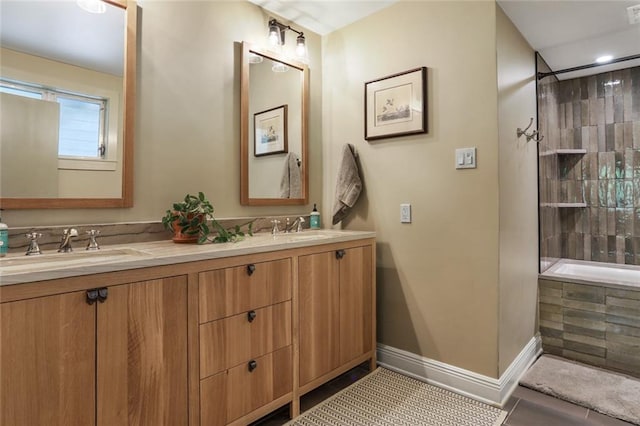 full bath featuring double vanity, tile patterned flooring, baseboards, and a sink