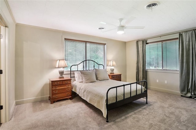 carpeted bedroom featuring ceiling fan, ornamental molding, visible vents, and baseboards