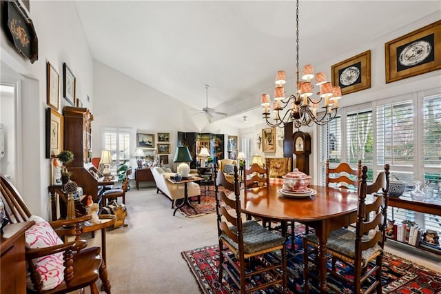 dining space with high vaulted ceiling, carpet, and ceiling fan with notable chandelier