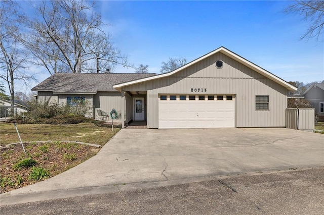 view of front of house with concrete driveway, a garage, and a shingled roof