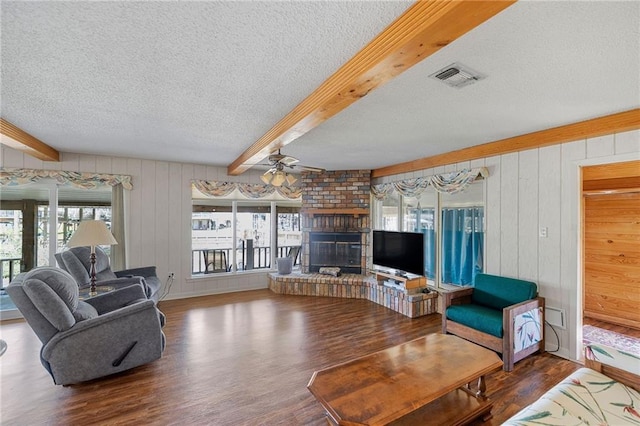 living area with a wealth of natural light, beamed ceiling, and visible vents