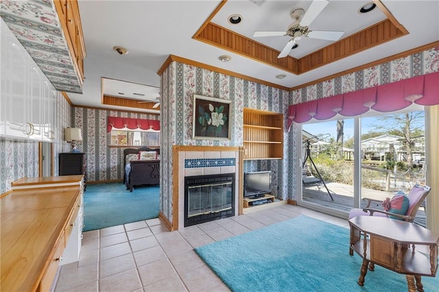 tiled living room with wallpapered walls, a raised ceiling, a fireplace, and a healthy amount of sunlight