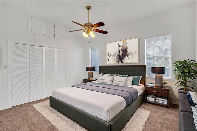 bedroom featuring light colored carpet, a closet, a ceiling fan, and baseboards