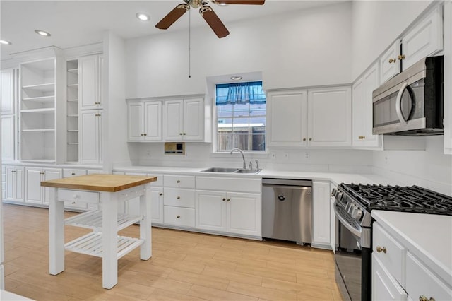 kitchen with stainless steel appliances, light countertops, white cabinetry, and a sink