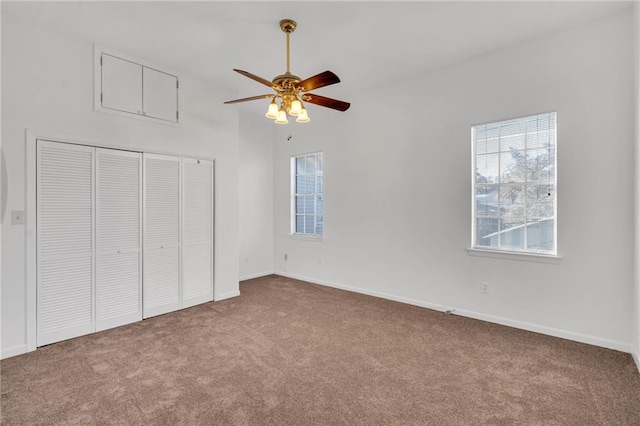 unfurnished bedroom with a closet, carpet, a ceiling fan, and baseboards