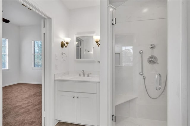 bathroom with a stall shower, vanity, and baseboards