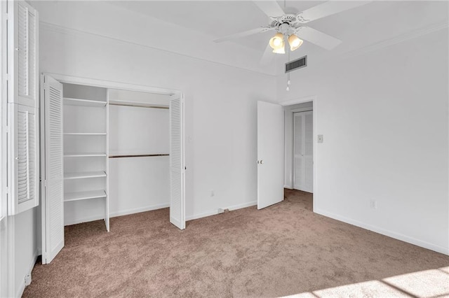 unfurnished bedroom with a closet, visible vents, carpet flooring, ceiling fan, and baseboards