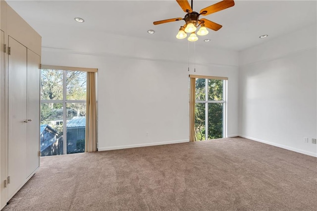 carpeted spare room featuring recessed lighting, a healthy amount of sunlight, and baseboards