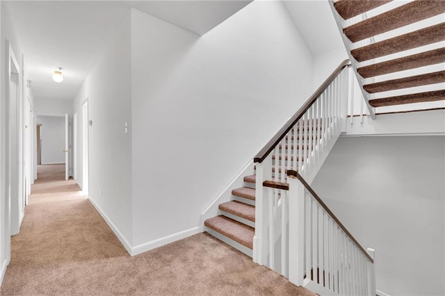 staircase featuring carpet flooring and baseboards