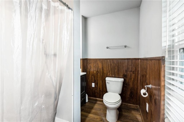 3030 Ridgeway Blvd, New Orleans, LA 70129 - full bathroom with a shower with curtain, toilet, wood finished floors, and a wainscoted wall