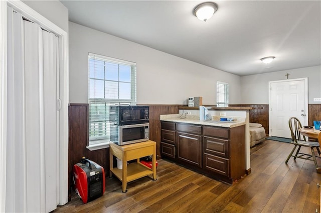 3030 Ridgeway Blvd, New Orleans, LA 70129 - kitchen featuring wooden walls, dark brown cabinets, dark wood finished floors, a wainscoted wall, and light countertops