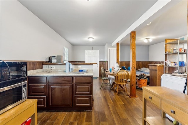 3030 Ridgeway Blvd, New Orleans, LA 70129 - kitchen featuring stainless steel microwave, dark wood-type flooring, wainscoting, and light countertops