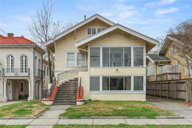 view of front of property featuring stairway and fence