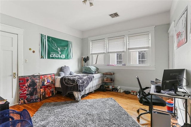 bedroom featuring wood finished floors and visible vents