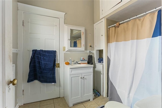 bathroom featuring tile patterned flooring, a shower with curtain, vanity, and toilet