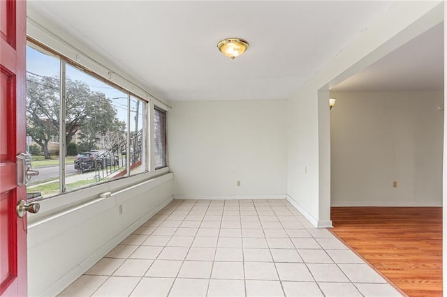 unfurnished room with light tile patterned flooring and baseboards