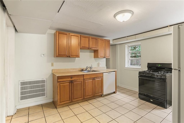 kitchen with light countertops, visible vents, light tile patterned flooring, a sink, and white appliances