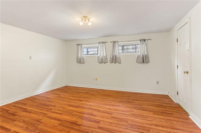 unfurnished room with baseboards and light wood finished floors