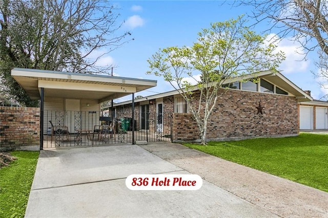 view of front of house featuring brick siding, fence, concrete driveway, a gate, and a front yard