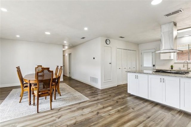 dining room with baseboards, wood finished floors, visible vents, and recessed lighting