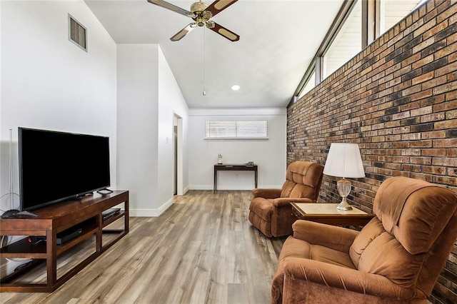 living room with visible vents, a ceiling fan, brick wall, wood finished floors, and baseboards