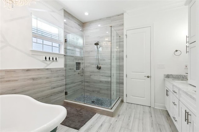 bathroom featuring a sink, a shower stall, double vanity, and a freestanding bath