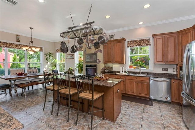 kitchen with stainless steel appliances, brown cabinetry, and a sink