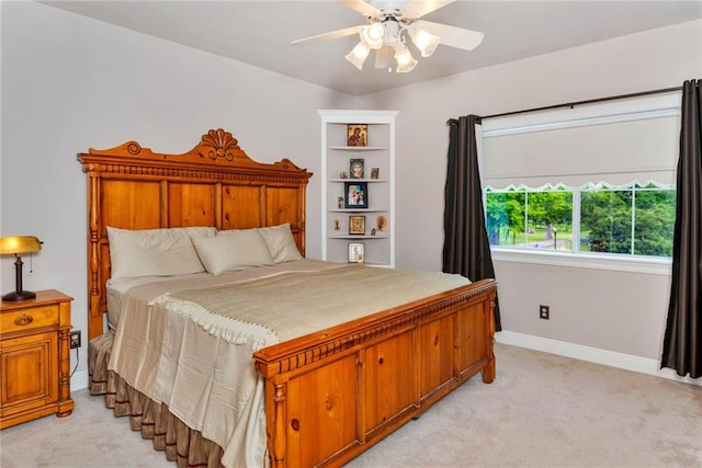 bedroom with a ceiling fan, light colored carpet, and baseboards